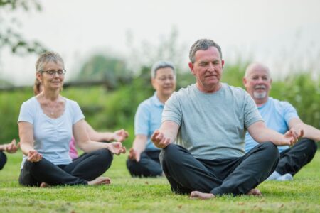 Un groupe de personnes âgées s'exerce à la méditation guidée.