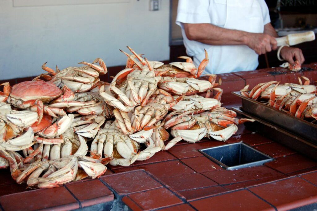 Un serveur apprête les commandes au restaurant folie crabe.