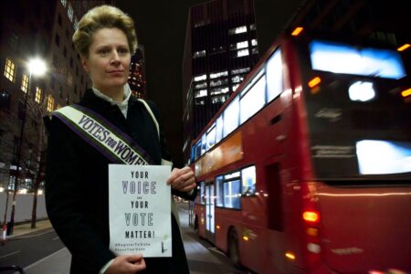 Une Suffragette dans les rues de Londres appelle les passants à exercer leur droit de vote