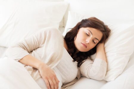 Une femme ayant amélioré son sommeil naturellement en créant un environnement de sommeil favorable.