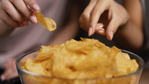 deux femmes mangent chips dans un bol
