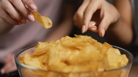 deux femmes mangent chips dans un bol