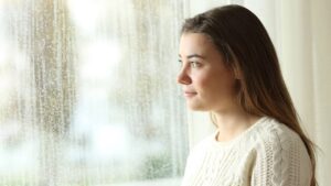 femme pensive regarde fenetre