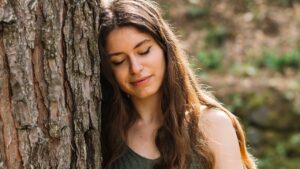 femme contre arbre sereine