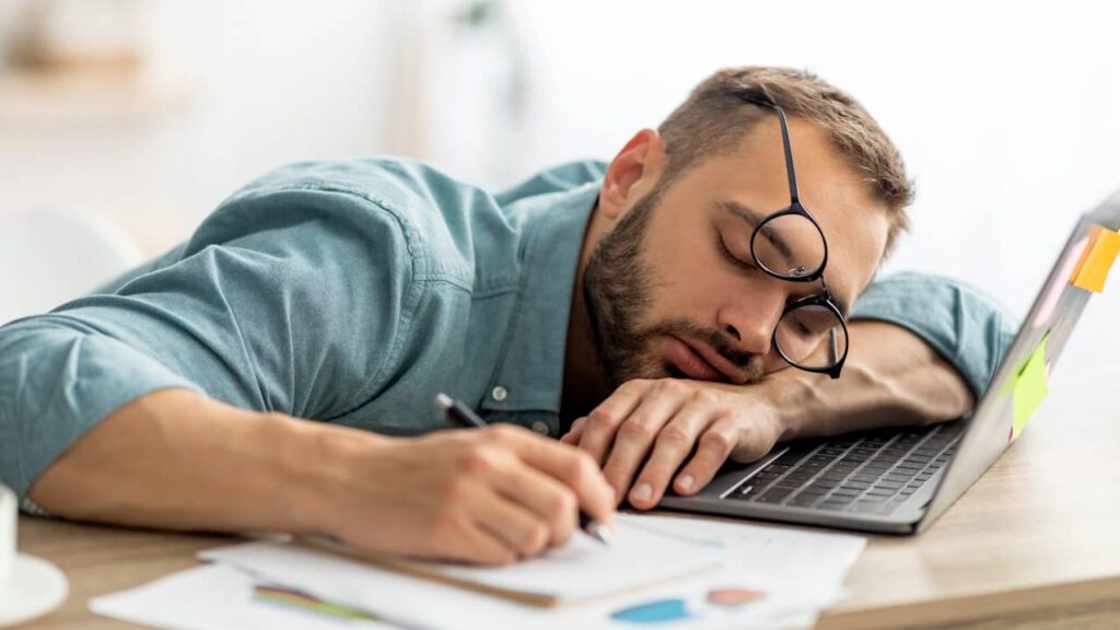 homme epuise dort bureau