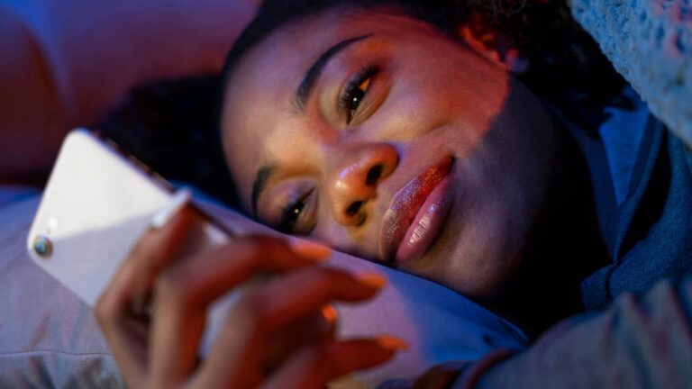 SMS bonne nuit : ces idées qui font vraiment craquer (et auxquels personne ne résiste) femme sourit telephone