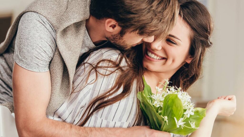 homme offre fleurs femme heureuse