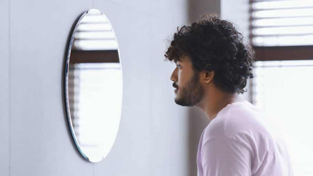 Soliloquer : que signifie ce verbe qui désigne le fait de parler seul ? homme qui se parle miroir