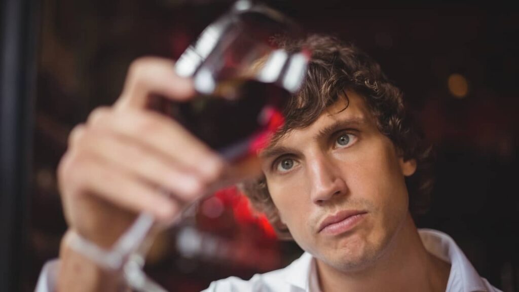 Comment reconnaître un vin qui a tourné ? Les signes qui ne trompent pas homme regarde couleur vin